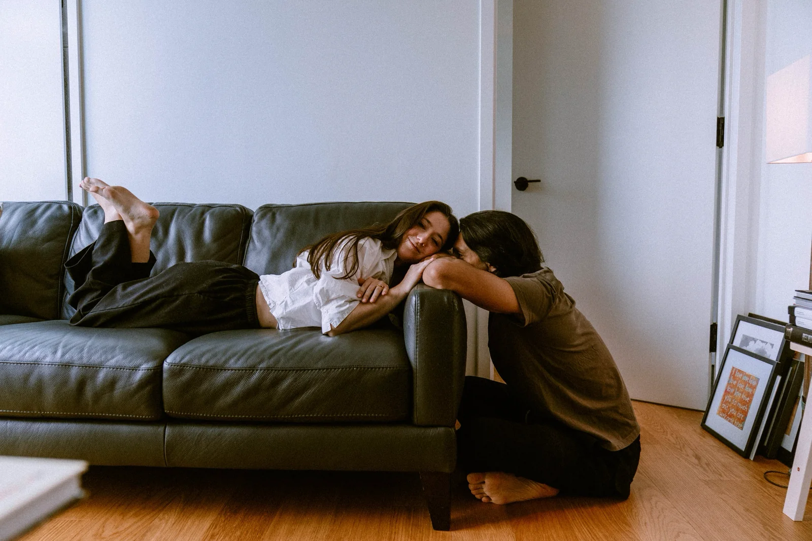 Couple poses at home: resting heads together on a living room sofa