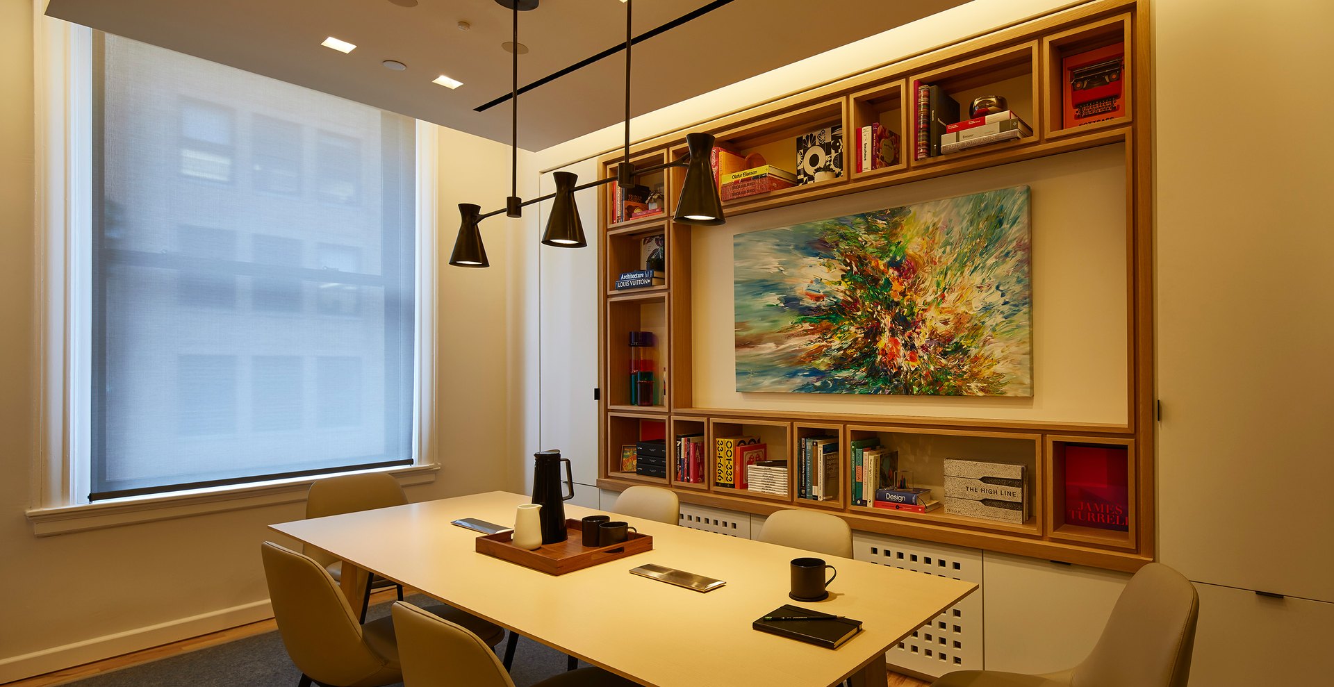 Room with overhead lighting lowered and perimeter lighting held dim for a presentation