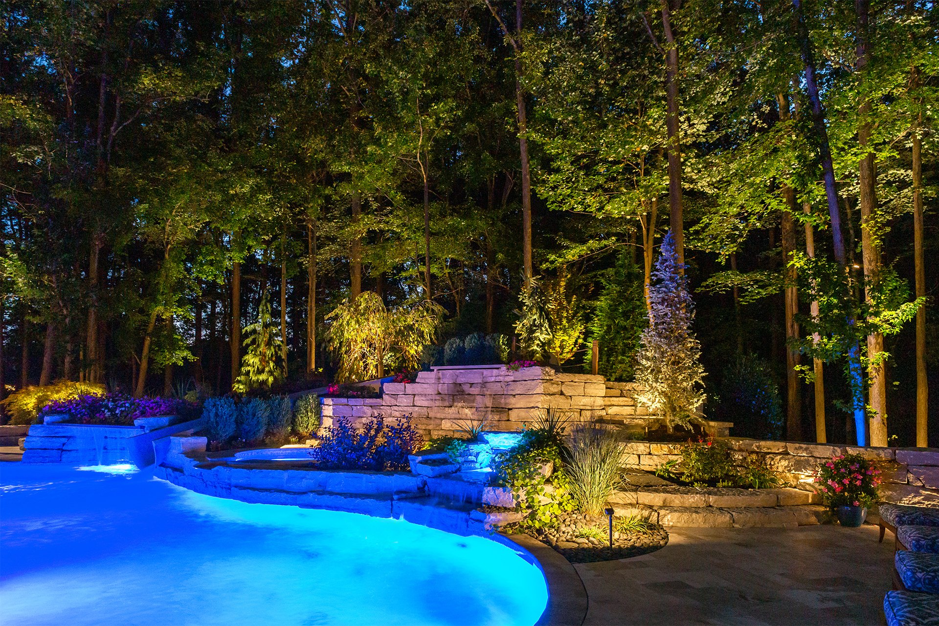Luxury pool and landscape with integrated nighttime lighting for outdoor entertaining