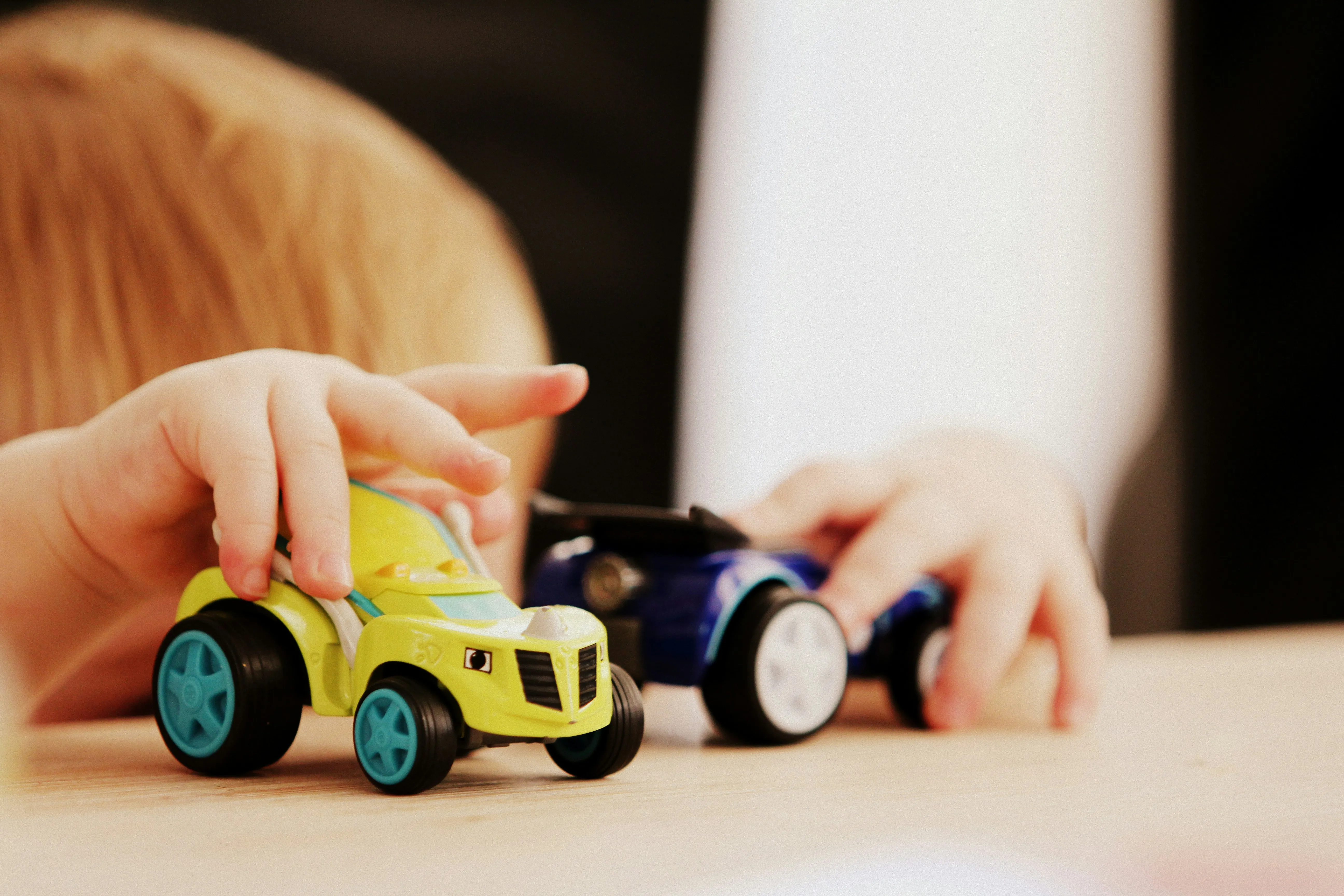 A child playing with small toy trucks