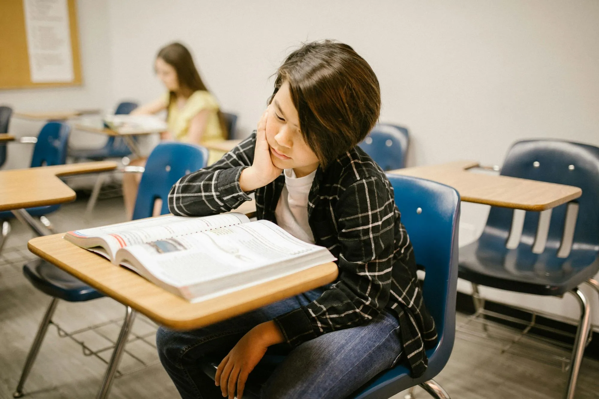 A child in a classroom who looks unhappy and isn't engaging