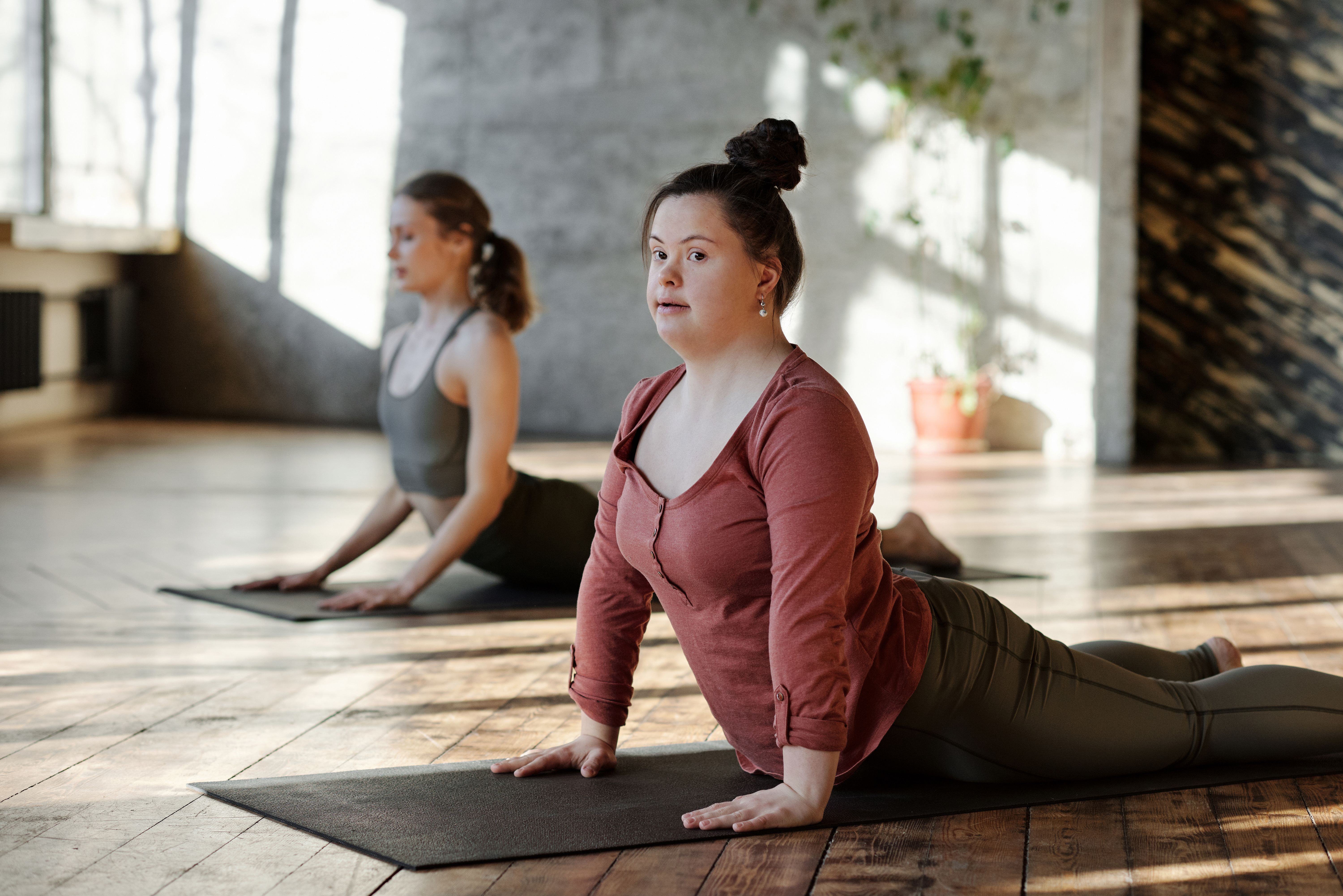 A girl with down syndrome practices in a yoga studio