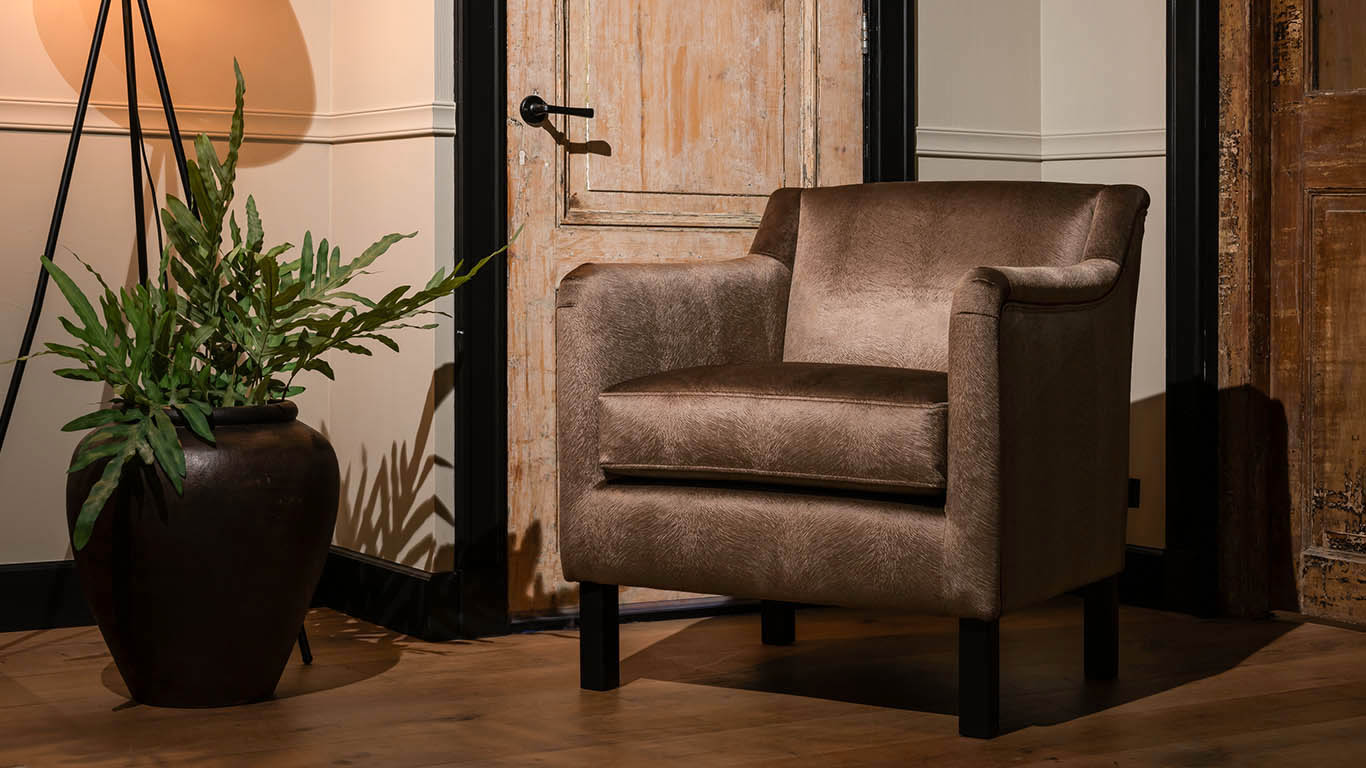 Bella in taupe stof met sierlijke vormgeving en houten poten.