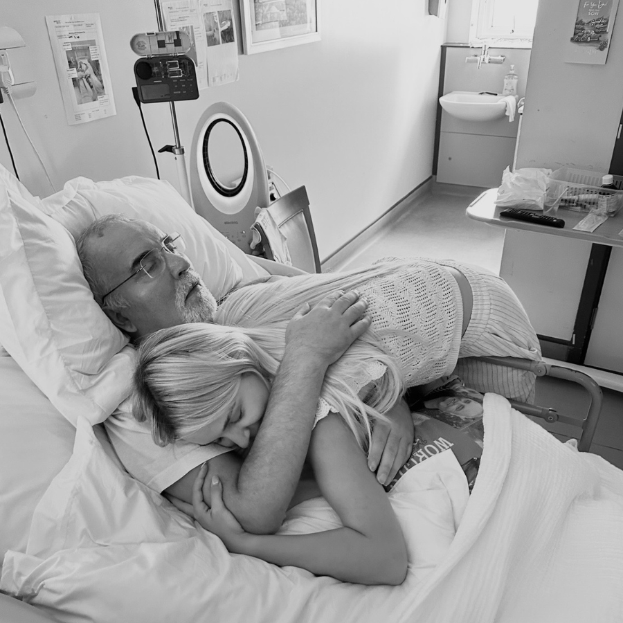 Shannon and her father, hugging each other in a hospital bed