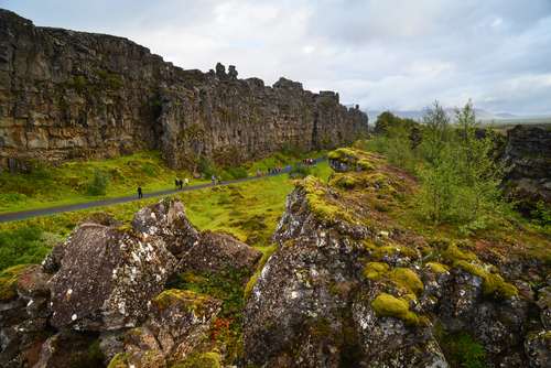 Tourists walking among the tectonic landforms of Þingvellir (Thingvellir) National Park, Iceland