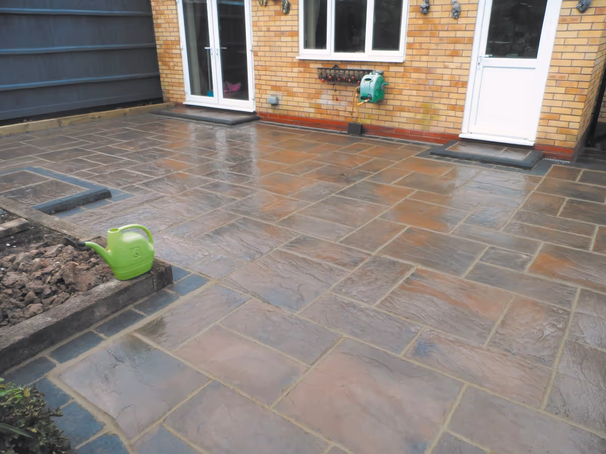 Two size autumn gold concrete patio with charcoal rumbled block and matching concrete steps built with key set kerbs - angle 1