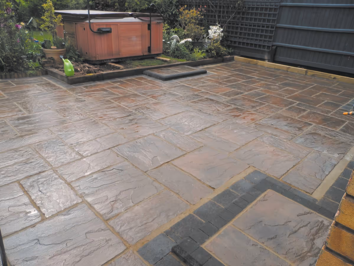 Two size autumn gold concrete patio with charcoal rumbled block and matching concrete steps built with key set kerbs - angle 2