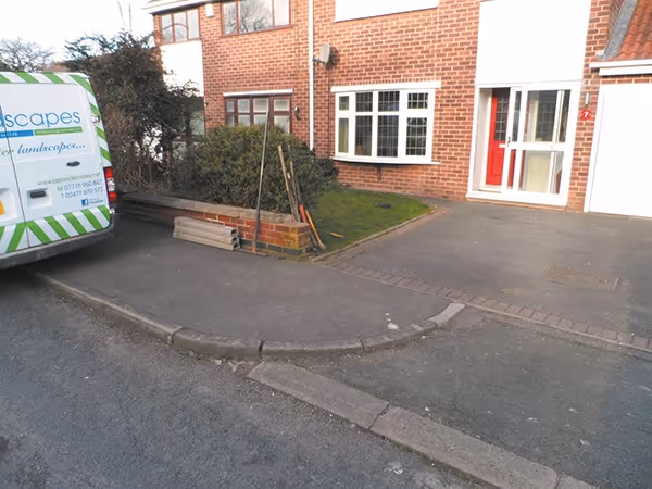 Charcoal Rumbled paving set driveway with a triple border using burnt willow, inset manhole tray, K.L kerb set planter and an ACO channel drainage system.