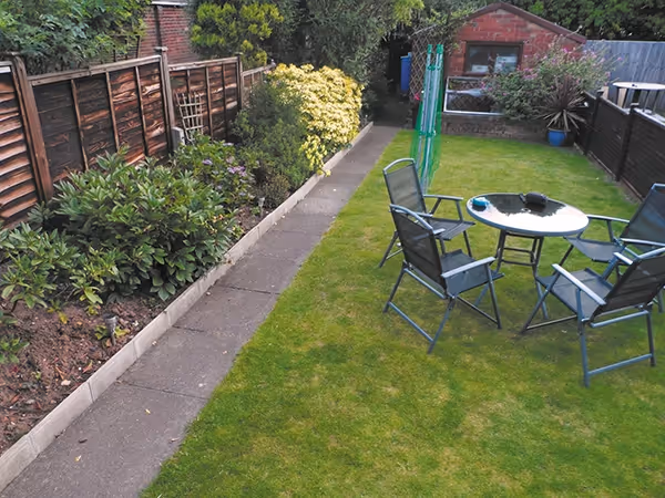 Mixed size autumn gold concrete patio, raised treated decking area and new lawn. 