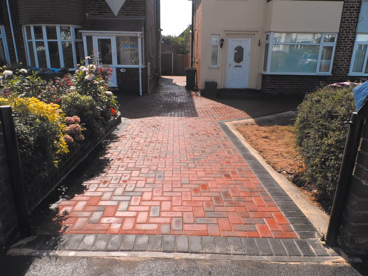 Brindle standard paving set driveway with charcoal borders, K.L kerb steps and planter retainers and an ACO channel drainage system