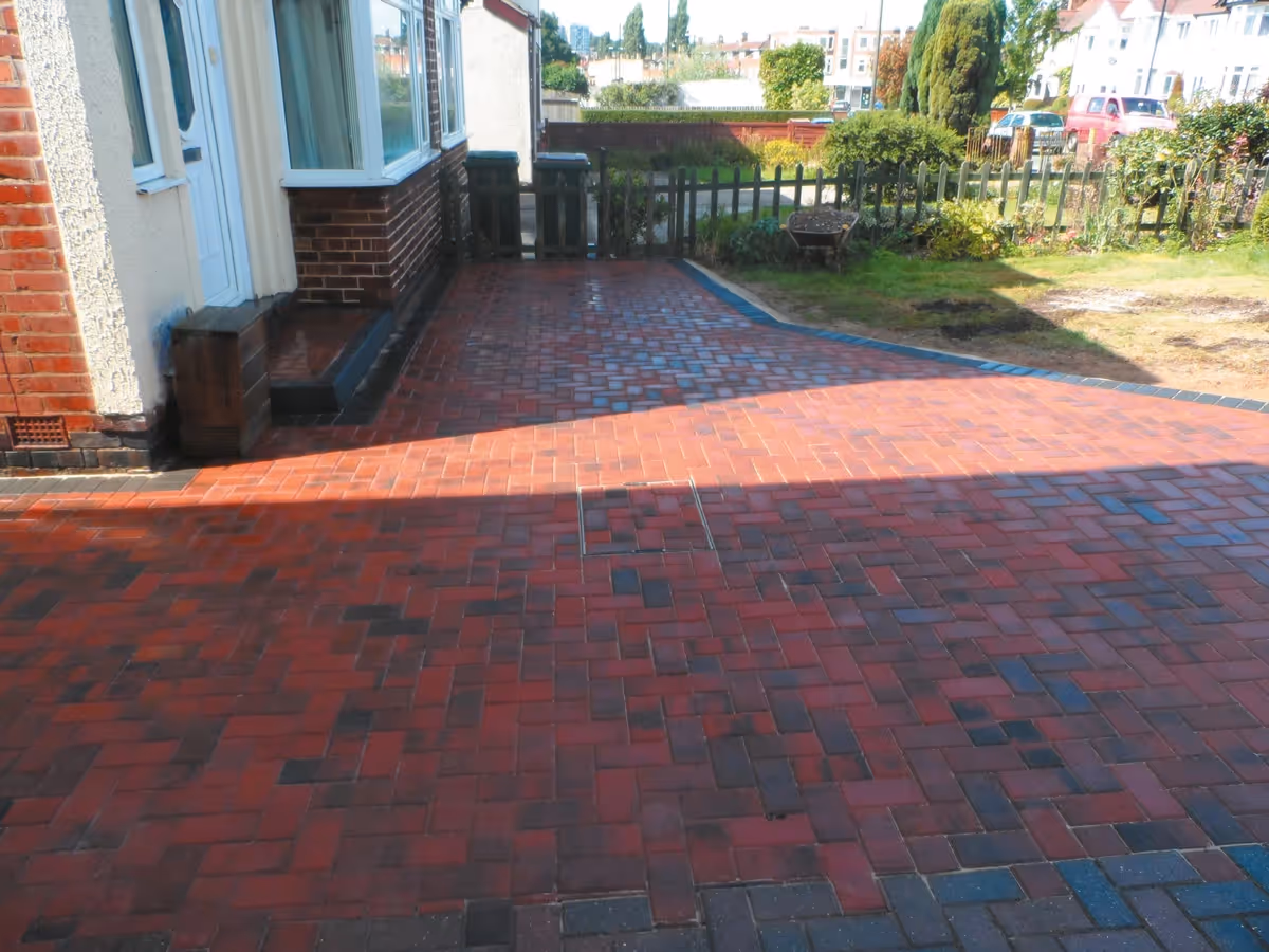 Brindle standard paving set driveway with charcoal borders, K.L kerb steps and planter retainers and an ACO channel drainage system - angle 1