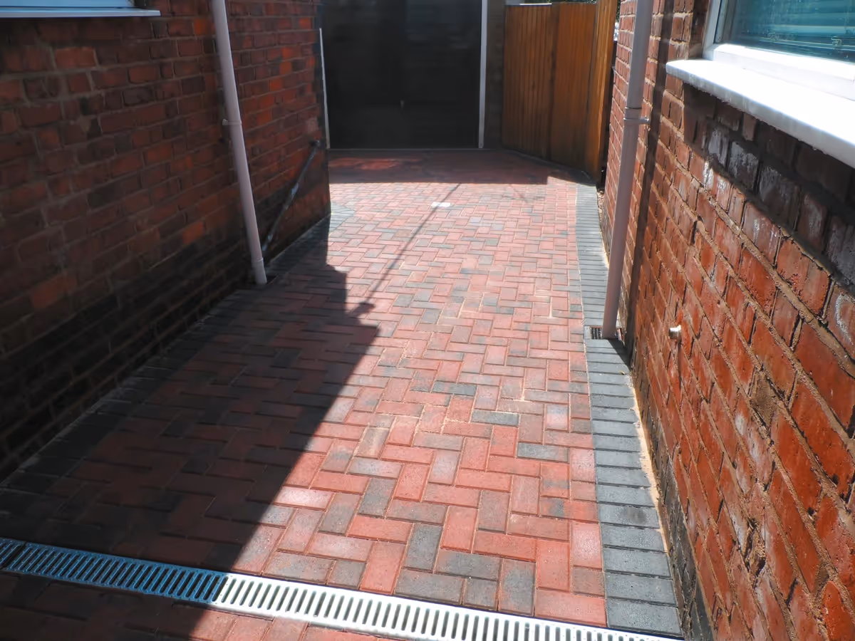 Brindle standard paving set driveway with charcoal borders, K.L kerb steps and planter retainers and an ACO channel drainage system - angle 3