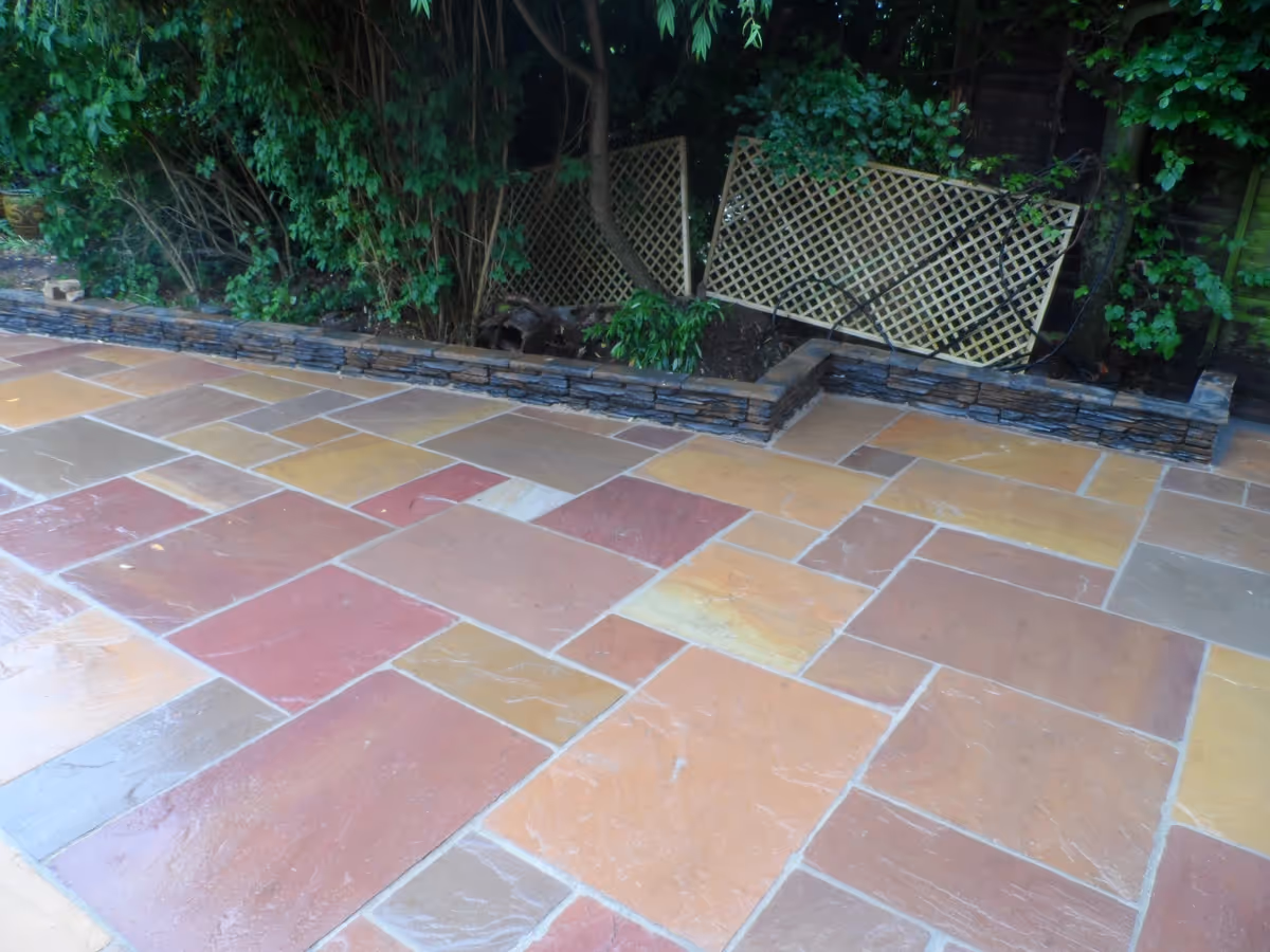 Modak natural stone patio with Raj natural stone sets, winter stone concrete walling and copings, gravel, stepping stones and decking - angle 5