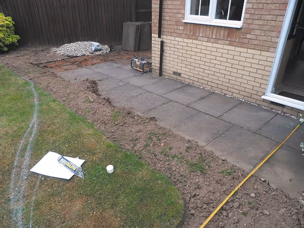 Mixed size camal natural stone patio with natural stone circle, edged with small sets and large charcoal rumbled block. 