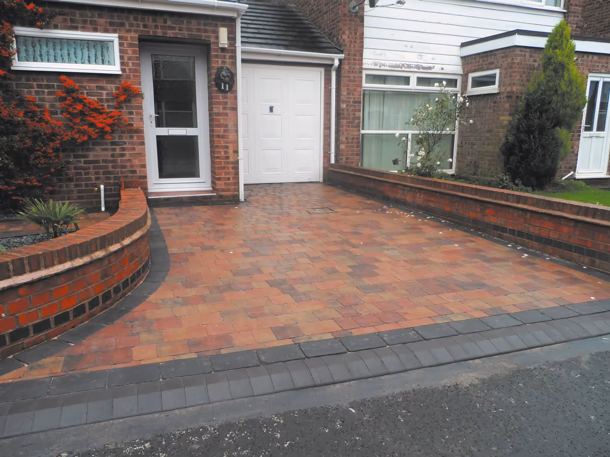 Autumn mix Rumbled paving set driveway and path with single borders in charcoal, K.L kerb set frontage and welsh green granite gravel area.