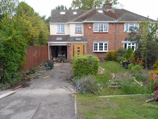 Brindle standard paving set driveway with triple borders using charcoal, Aco channel drainage system and a large planter area.
