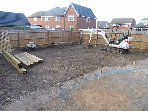 Mixed size camal natural stone patio with large charcoal rumbled block, new lawn edged with rumbled block border and bespoke pergola seating area. 