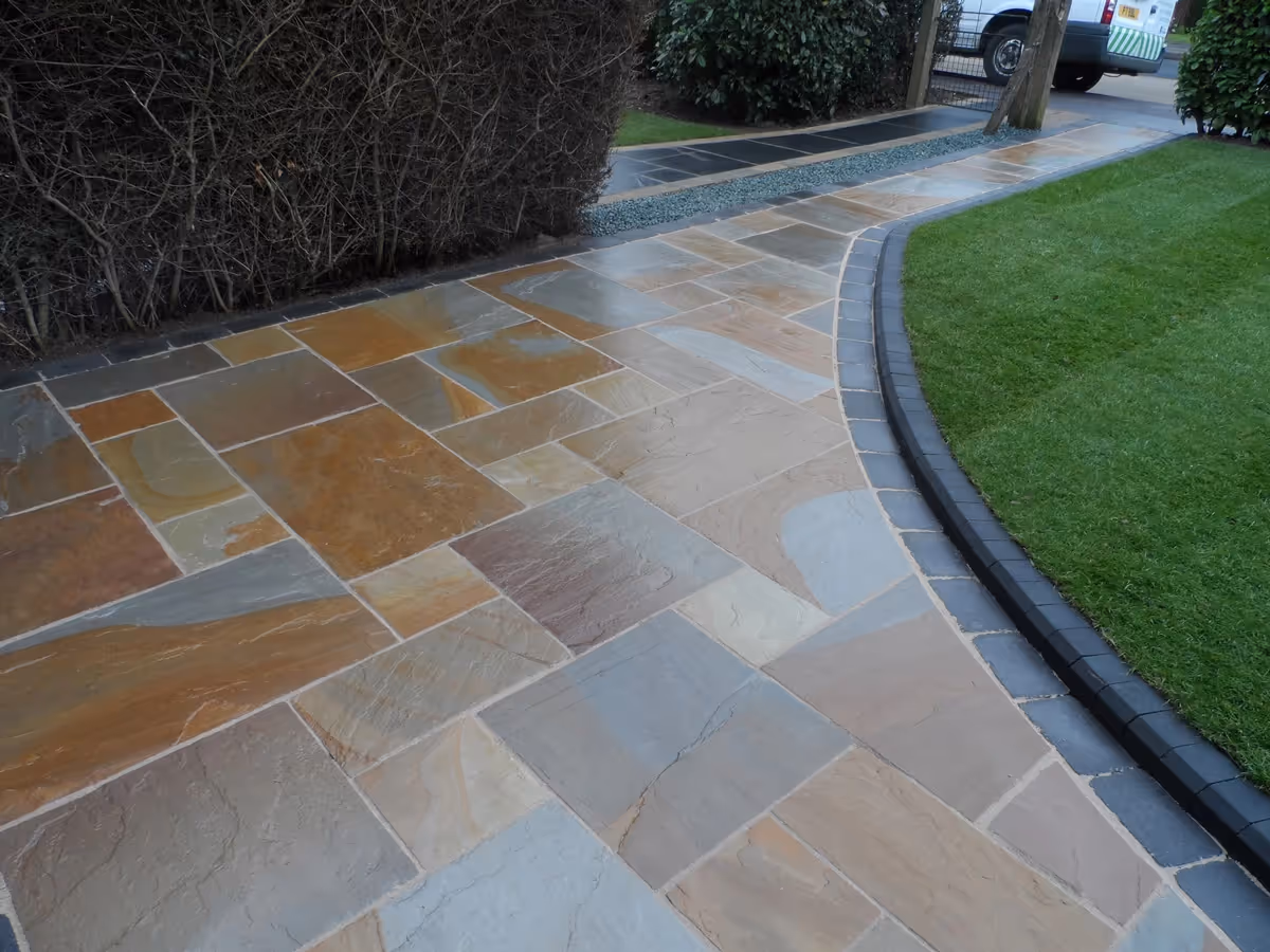 Camel Indian natural stone with rumbled charcoal borders, K.S kerb sets, ACO channel drainage system and new lawn using Rolawn medallion turf - angle 4