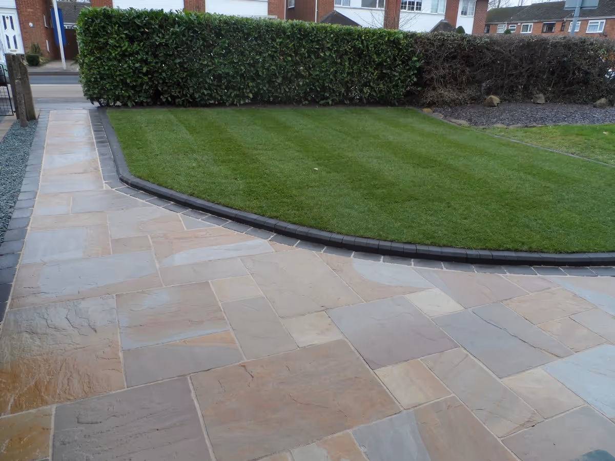 Camel Indian natural stone with rumbled charcoal borders, K.S kerb sets, ACO channel drainage system and new lawn using Rolawn medallion turf - angle 2