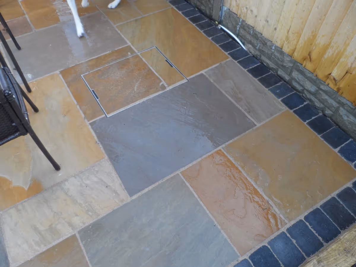 Mixed size camal natural stone patio with large charcoal rumbled block and sleeper planter - angle 4