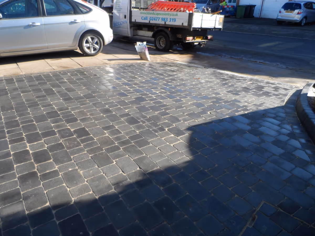 Charcoal Rumbled paving set driveway with K.L kerb planter and an ACO channel drainage system