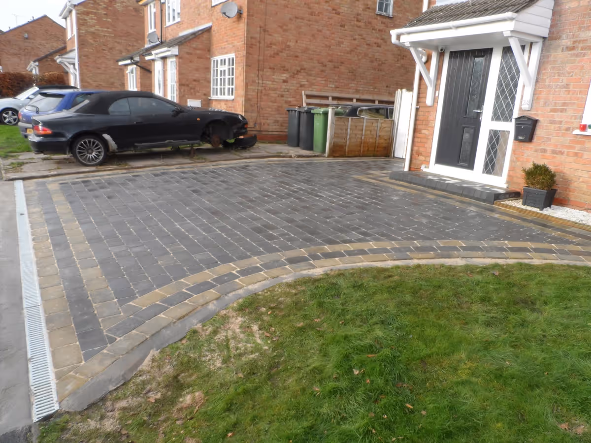 Charcoal Rumbled paving set driveway with triple border in burnt willow, K.L kerb step and ACO channel drainage system.