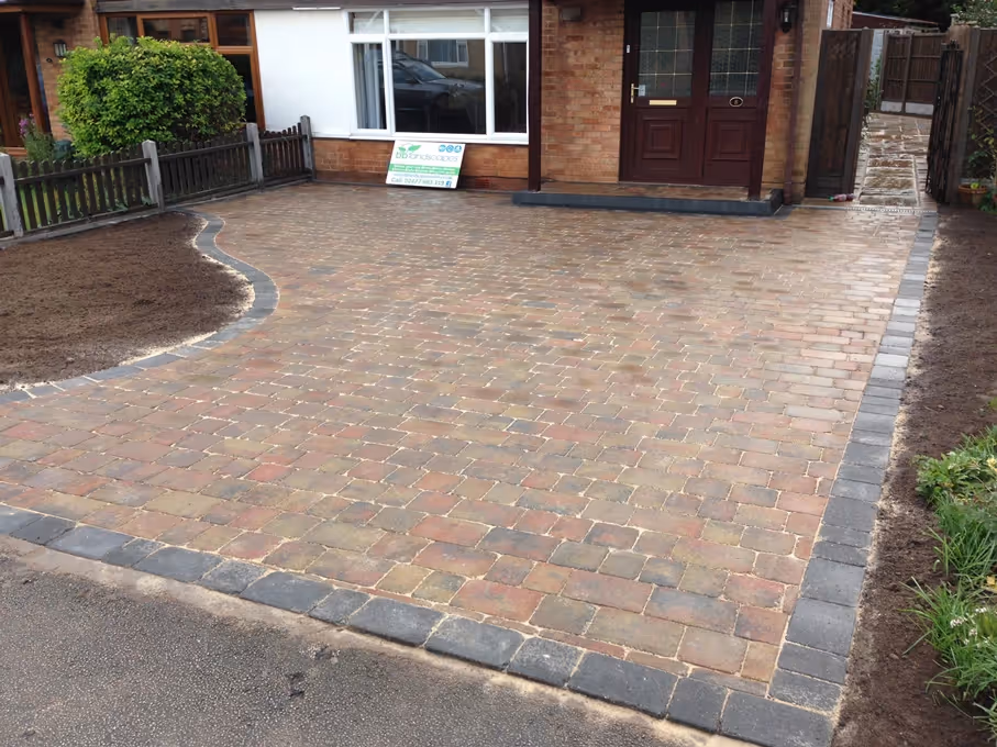 Autumn mix Rumbled paving set driveway with single charcoal border, K.L kerb platform step and large planter area