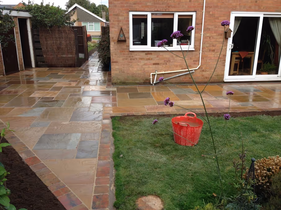 Mixed size camal natural stone patio with three size autumn mix rumbled block border - angle 1