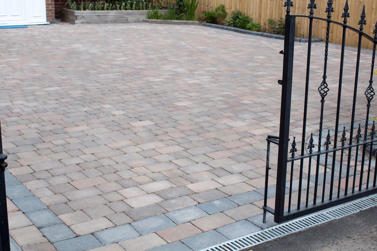 Autumn mix Rumbled paving set driveway with timber planter and ACO channel drainage system - angle 1
