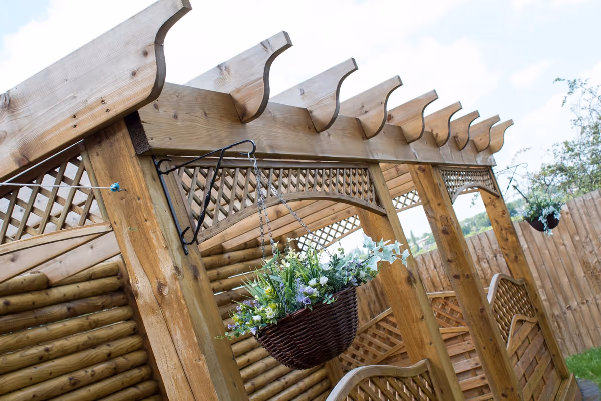 Mixed size Two tone natural stone patio with large charcoal rumbled block, bespoke timber frame pergola seating area. 