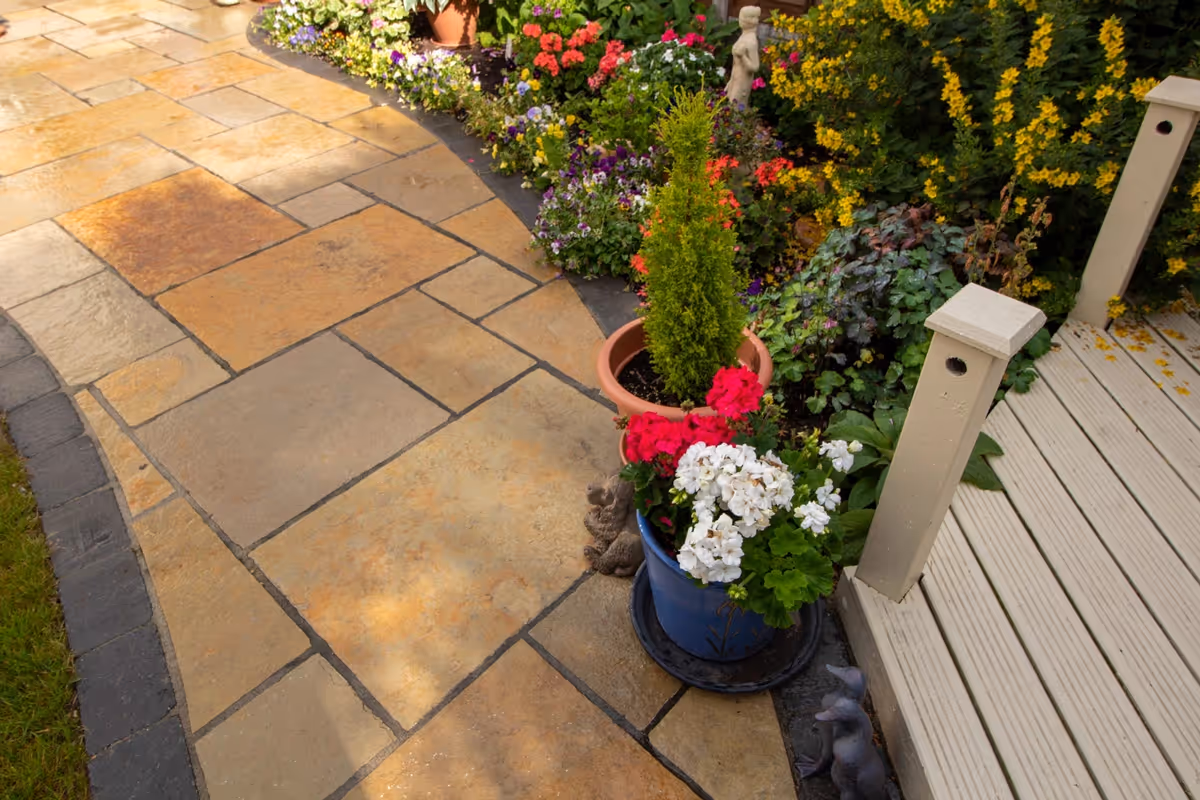 Mixed size yellow limestone patio with large charcoal rumbled block.  - angle 1