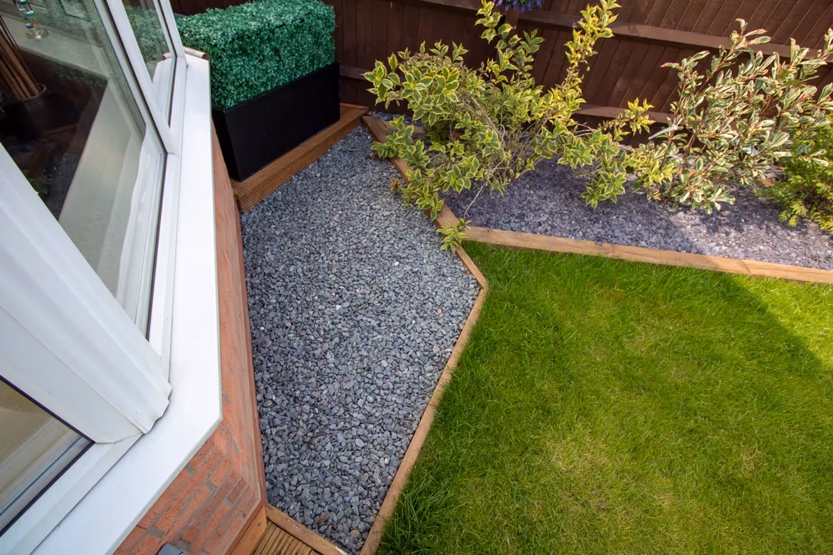 Mixed sized rustic porcelain patio, raised treated decking area and a new lawn and finished with blue slate.  - angle 3
