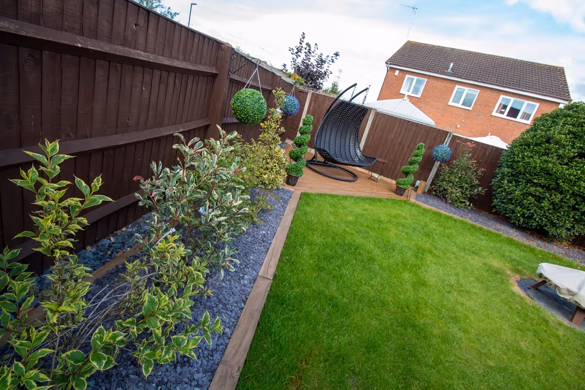 Mixed sized rustic porcelain patio, raised treated decking area and a new lawn and finished with blue slate.  - angle 4