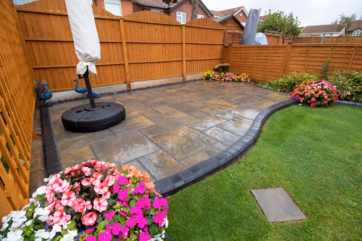 Rutland Winter Stone, 3 size paving with a Granite Resin based jointing compound. A standard Charcoal Paver around perimeters. A small Charcoal Kerb Set to retain planters. Plumb Slate decorative stones.