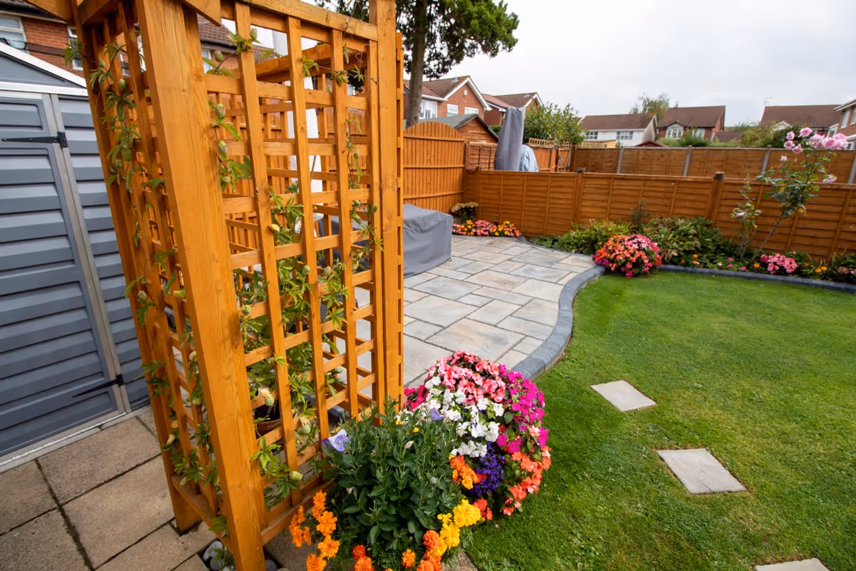 Rutland Winter Stone, 3 size paving with a Granite Resin based jointing compound. A standard Charcoal Paver around perimeters. A small Charcoal Kerb Set to retain planters. Plumb Slate decorative stones. - angle 2