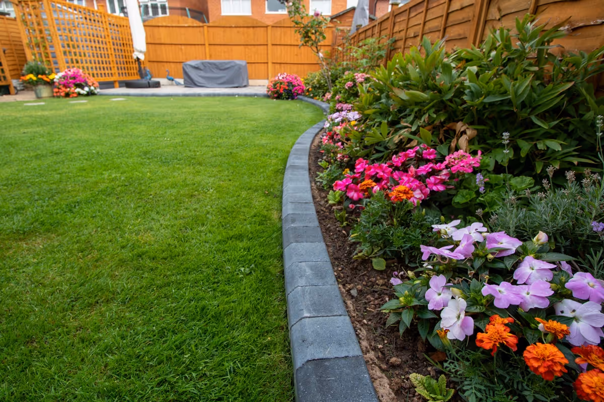 Rutland Winter Stone, 3 size paving with a Granite Resin based jointing compound. A standard Charcoal Paver around perimeters. A small Charcoal Kerb Set to retain planters. Plumb Slate decorative stones. - angle 1