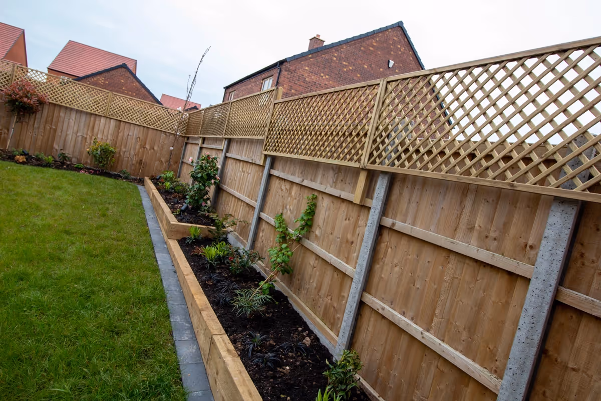 Raised-toped Total Stone Grigio porcelain slabs with Charcoal curb set. Venetian-style screening with downlights. Sleeper beds. Charcoal pencil edge paving border - angle 5
