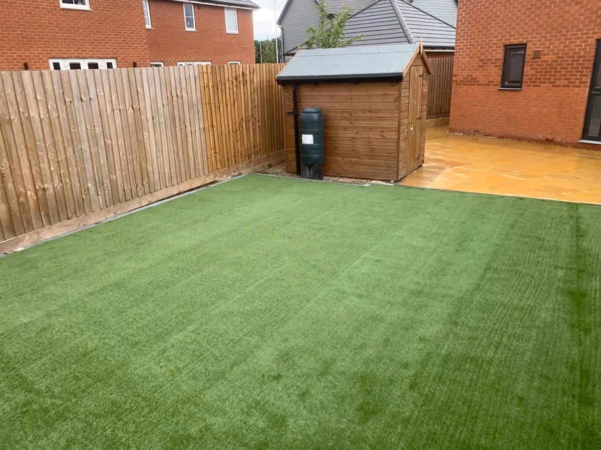 450x450 buff riven slabs with standard charcoal paving. Artificial lawn.