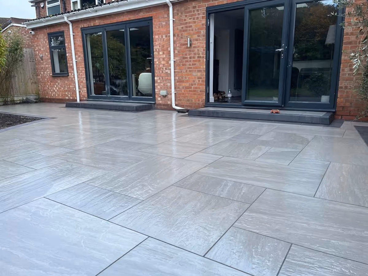 Kandla grey mixed-size porcelain with charcoal pencil edge paving. Charcoal KL kerb steps