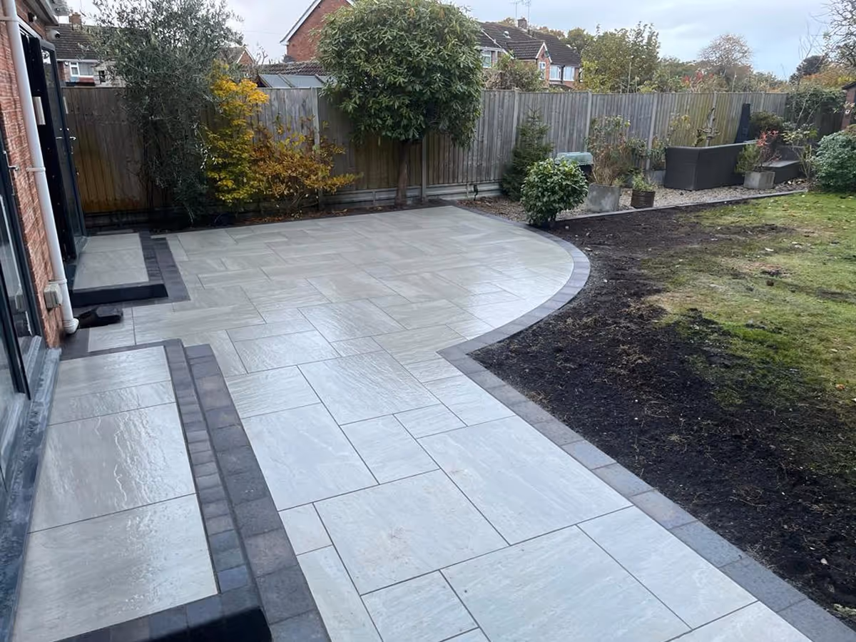 Kandla grey mixed-size porcelain with charcoal pencil edge paving. Charcoal KL kerb steps- angle 1