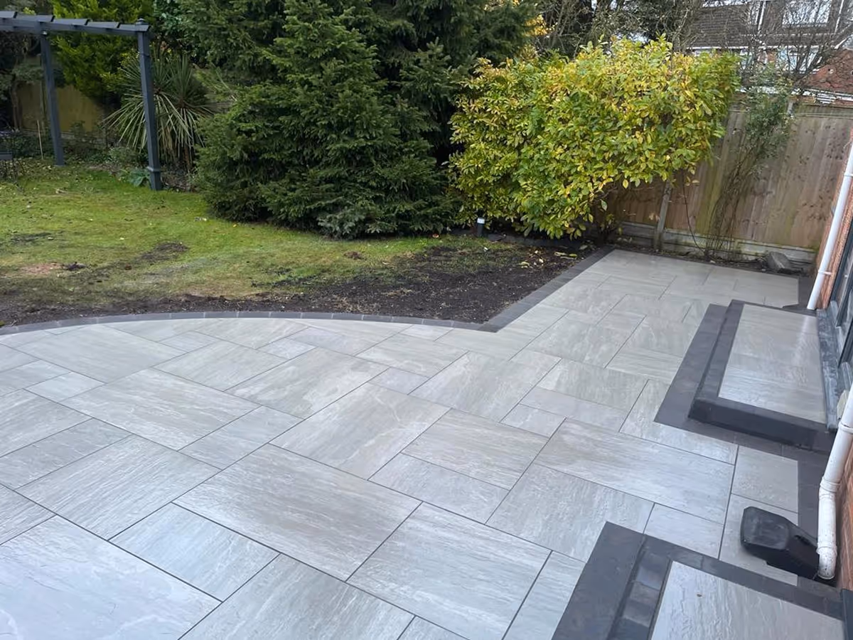 Kandla grey mixed-size porcelain with charcoal pencil edge paving. Charcoal KL kerb steps- angle 2