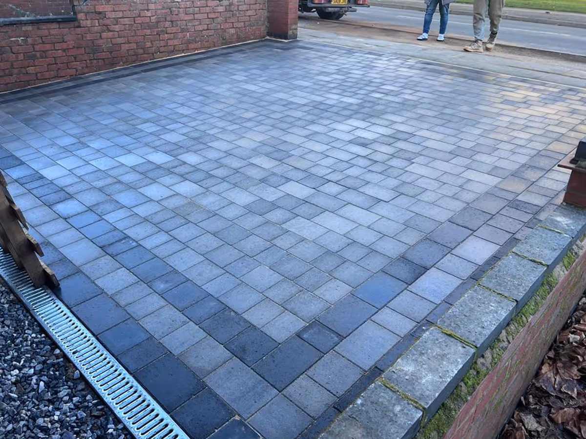 Silver grey pencil edge mixed-size paving. Triple border using charcoal pencil edge paving. ACO drainage system
