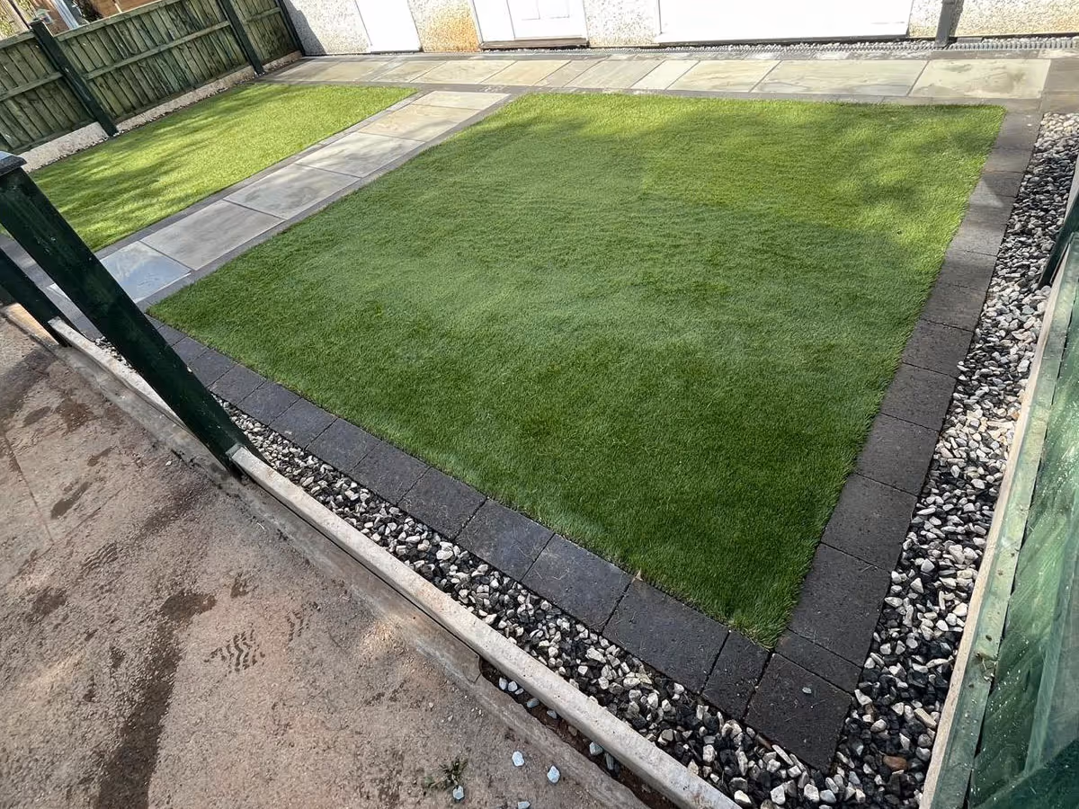 Natural stone patio with charcoal pencil edge paving and artificial lawn - angle 5