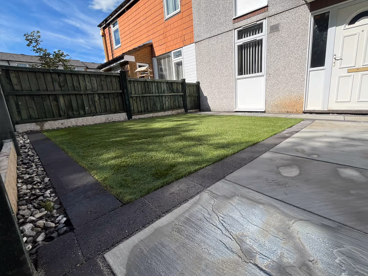 Natural stone patio with charcoal pencil edge paving and artificial lawn - angle 6
