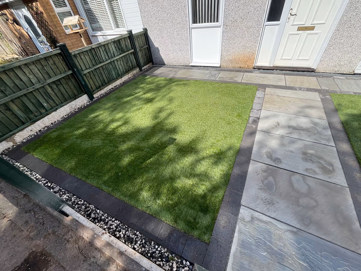 Natural stone patio with charcoal pencil edge paving and artificial lawn - angle 7