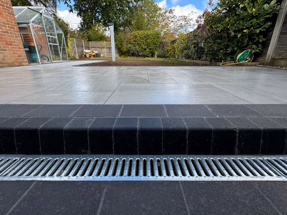 Total Stone Grigio porcelain patio with charcoal pencil edge paving and ACO drain - angle 2