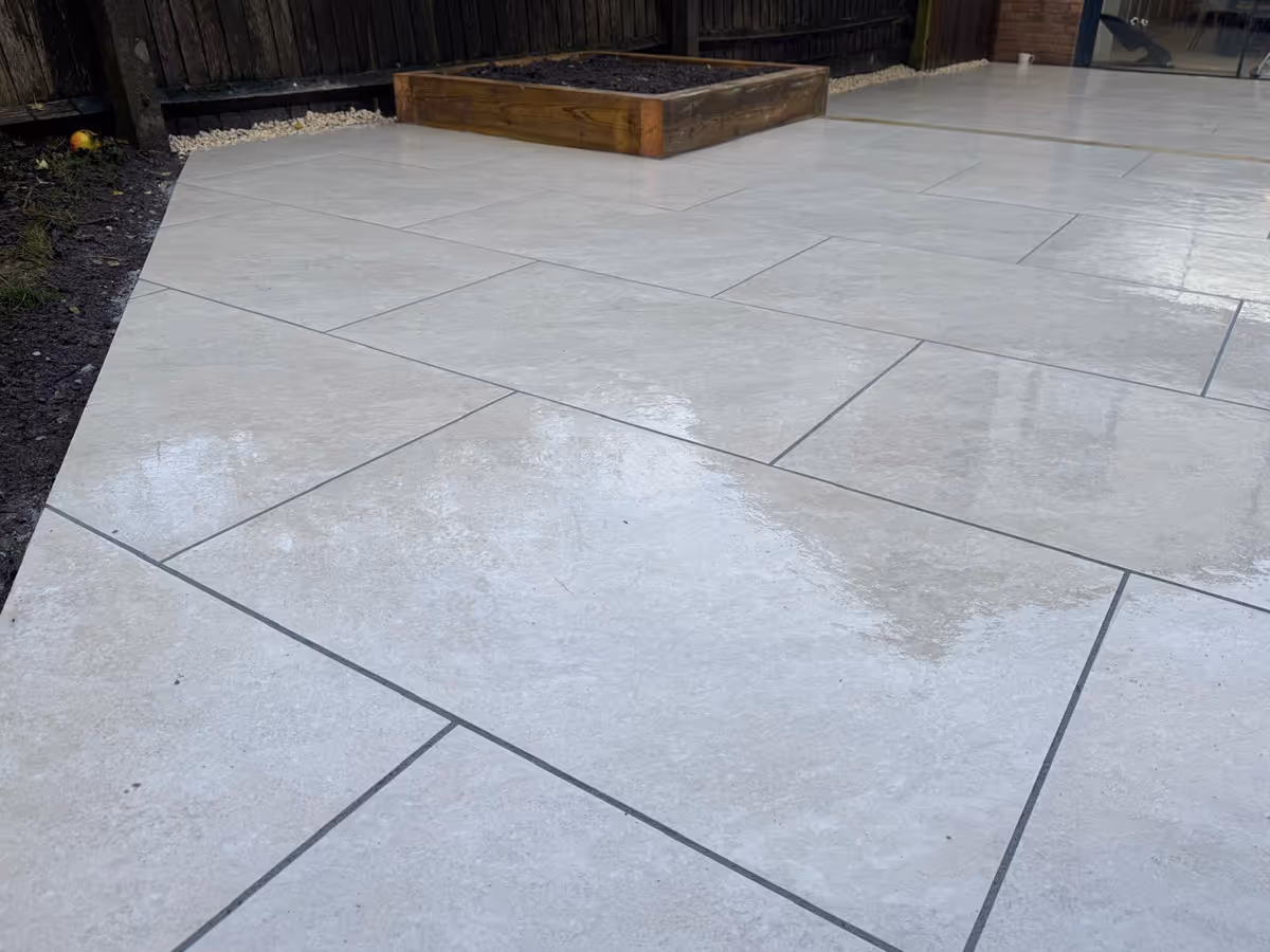 Grey porcelain patio with sleeper retainers and decorative chipping