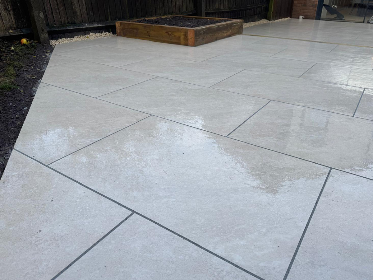 Grey porcelain patio with sleeper retainers and decorative chipping