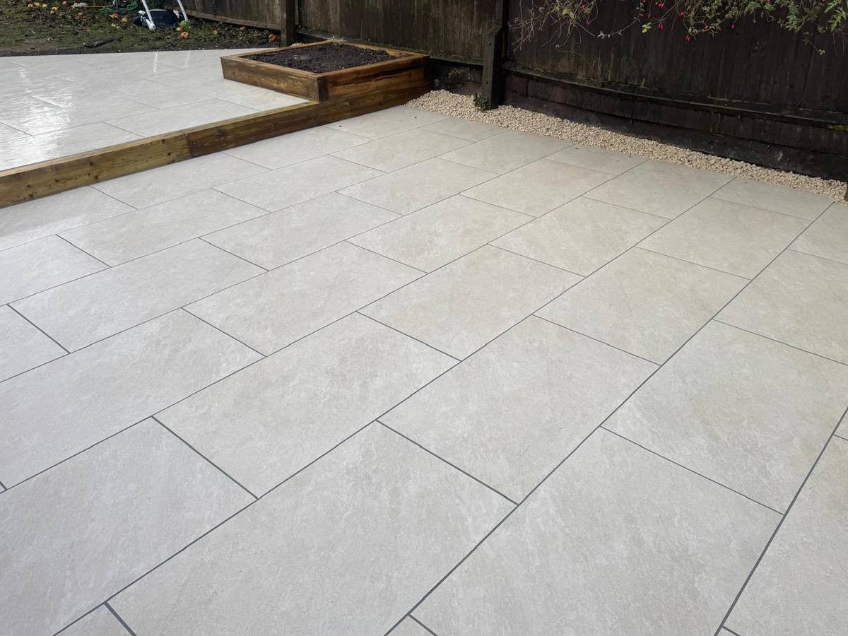 Grey porcelain patio with sleeper retainers and decorative chipping - angle 6