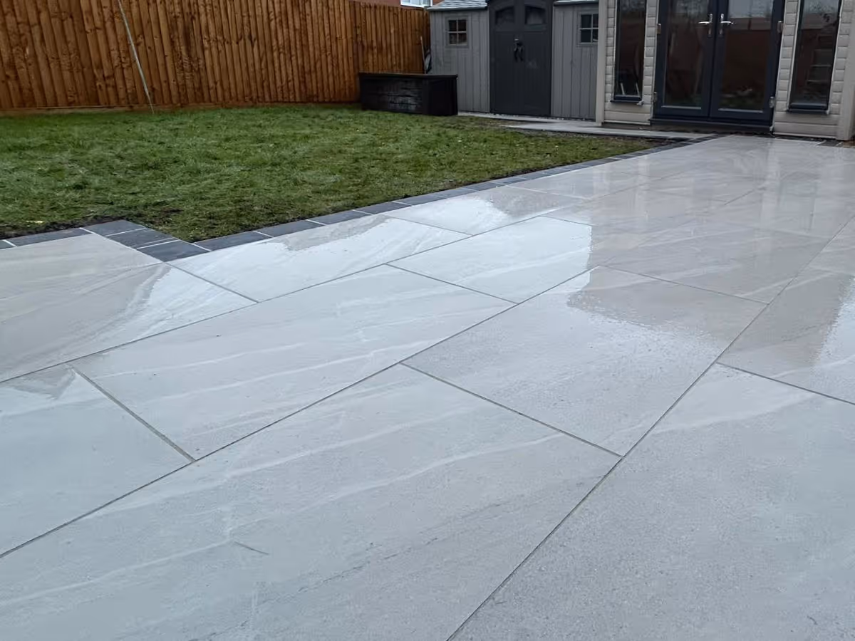 Grey porcelain patio with charcoal pencil edge paving. 